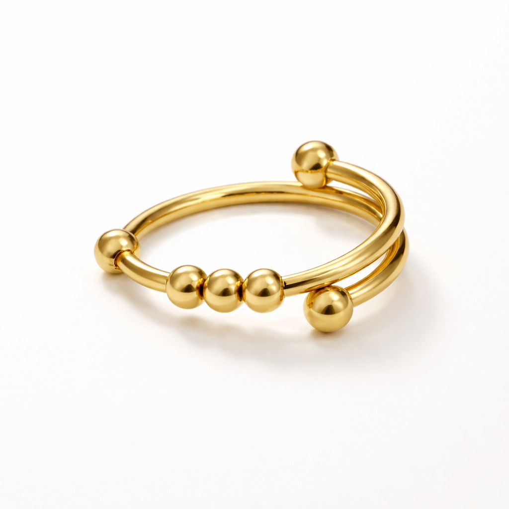 Gold ring with spherical beads on a white background