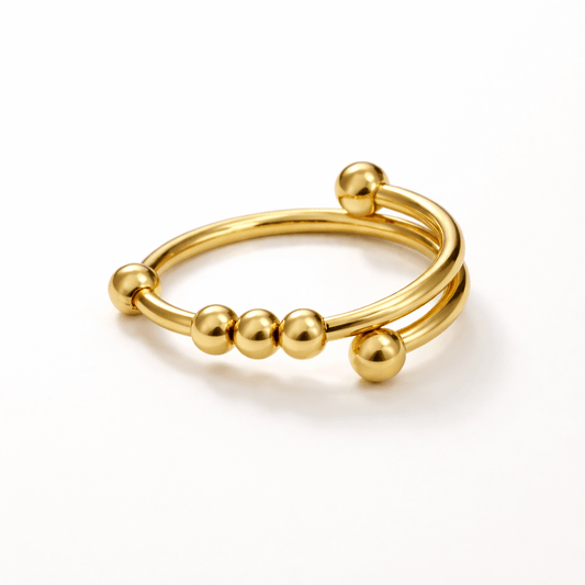 Gold ring with spherical beads on a white background