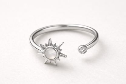 Silver open ring with sun design on a white background