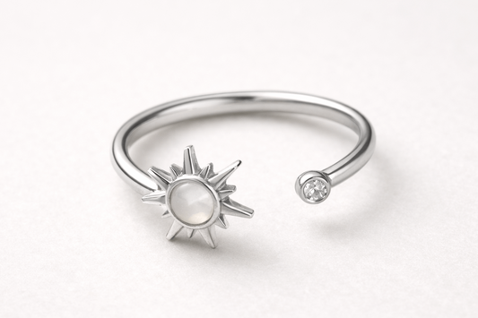 Silver open ring with sun design on a white background
