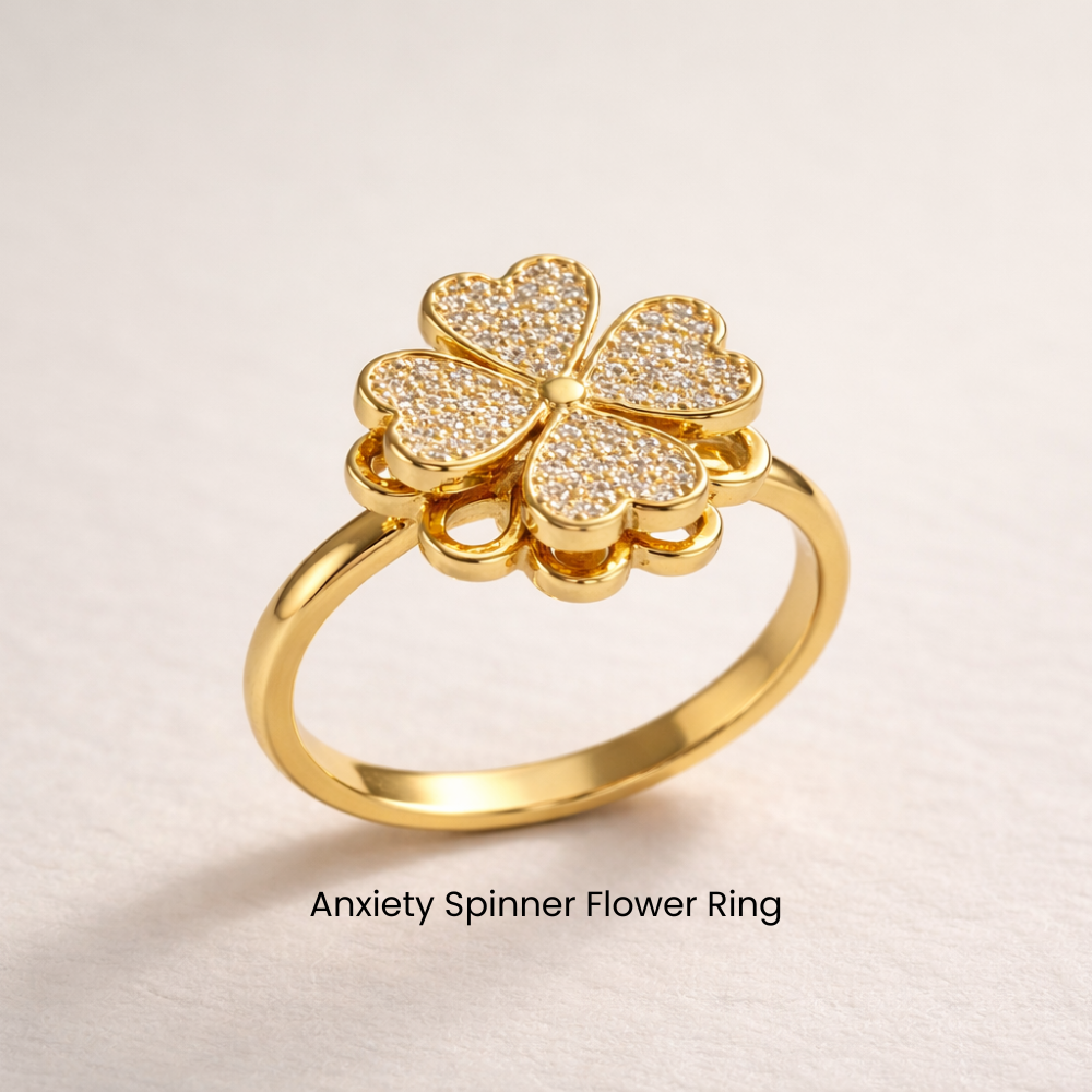 Gold anxiety spinner flower ring on a light beige background