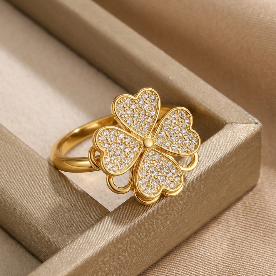 Gold four-leaf clover ring with diamonds on a beige jewelry box