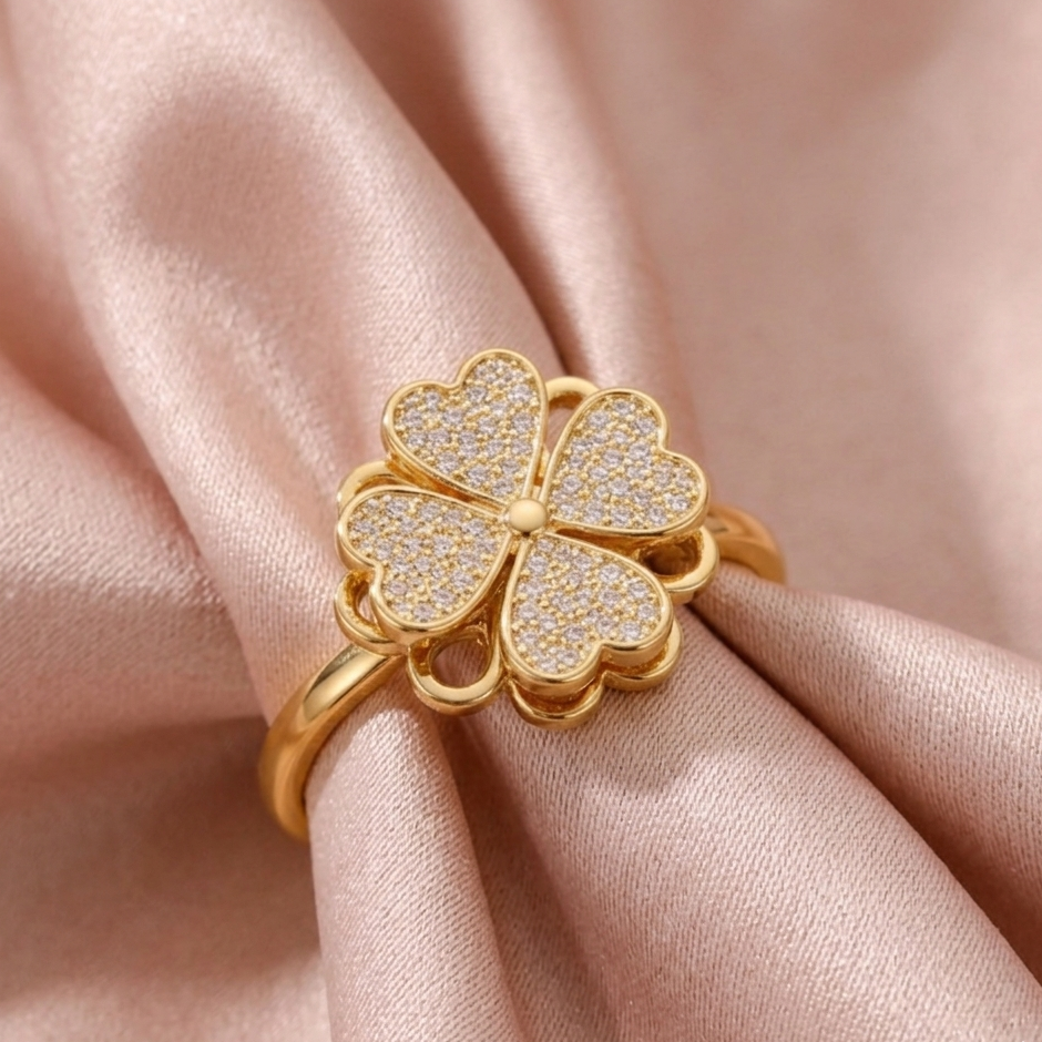 Gold ring with diamond accents on a pink fabric background