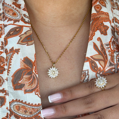Person wearing a gold necklace with a star-shaped pendant on a patterned fabric background