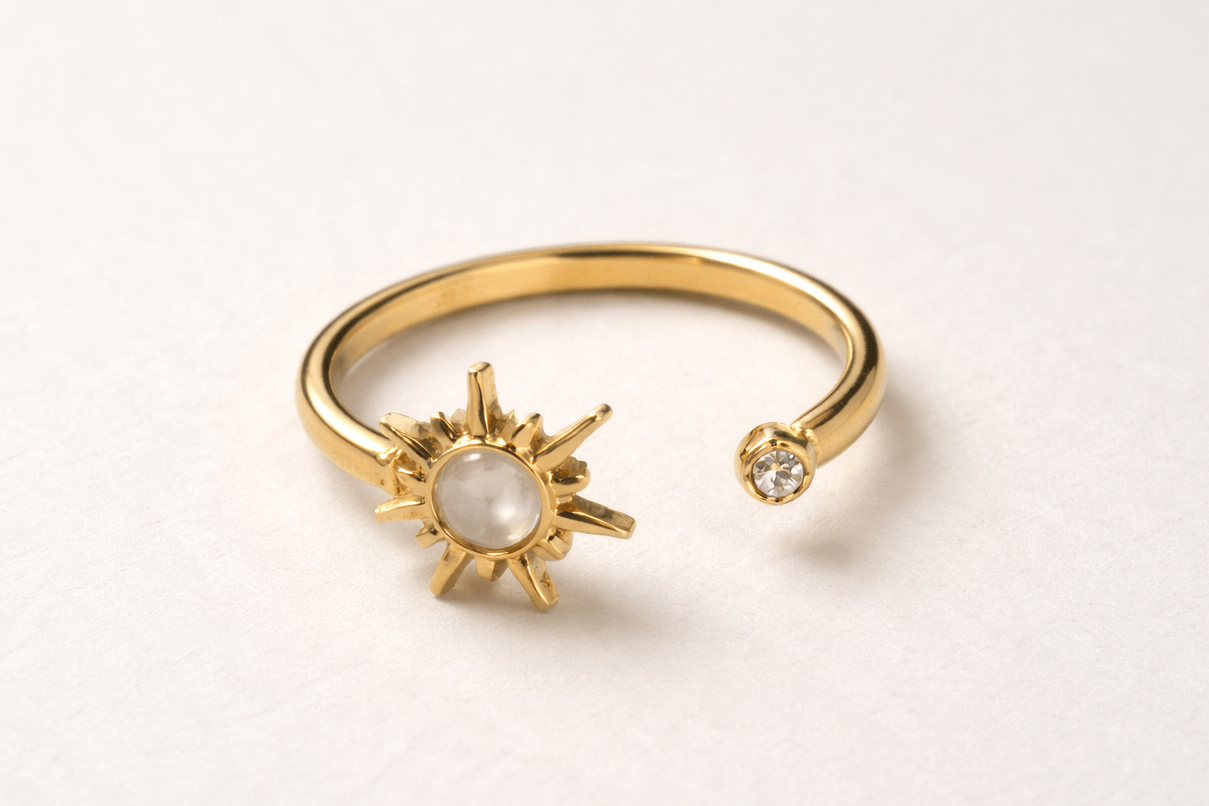 Gold bracelet with sun and moon design on a light gray background