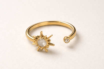 Gold bracelet with sun and moon design on a light gray background